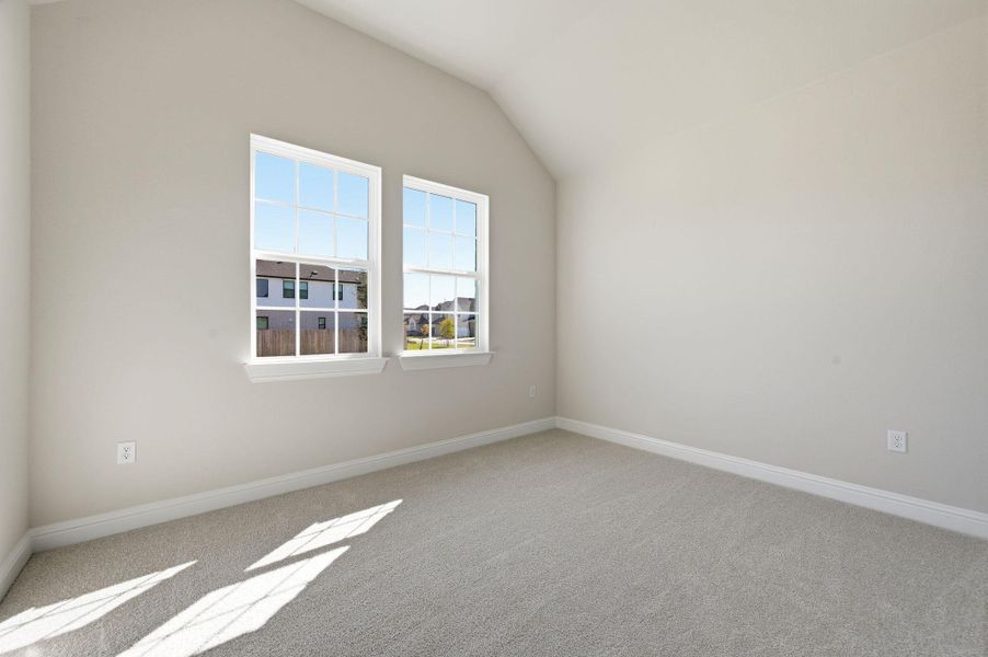 Spare room featuring light carpet and vaulted ceiling Spare room featuring light carpet and vaulted ceiling
