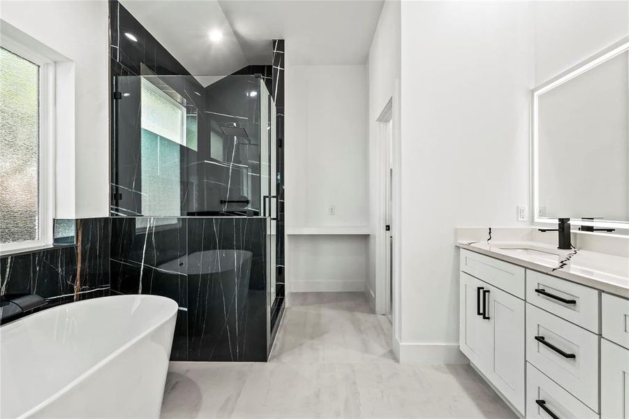 Full bath with a soaking tub, vanity, and a shower stall