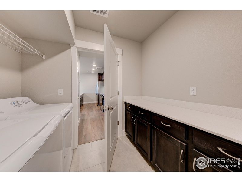 Laundry room w/ built in cabinets & quartz countertop - finishes may vary