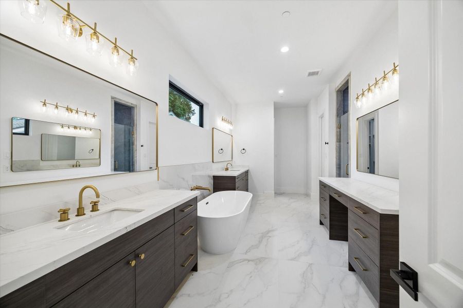The over sized free standing soaker tub anchors the space. Both sinks are under-mount for a clean look. High end plumbing and lighting here as elsewhere throughout the house.