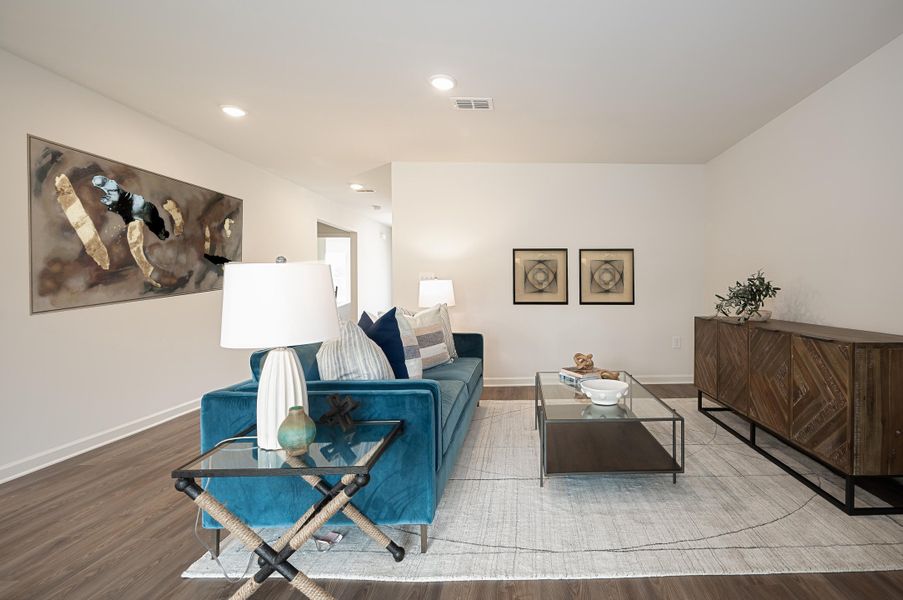 A living room with a bed and a desk.
