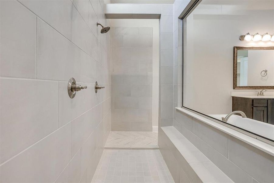 Bathroom with vanity, a tile shower, and tile patterned floors