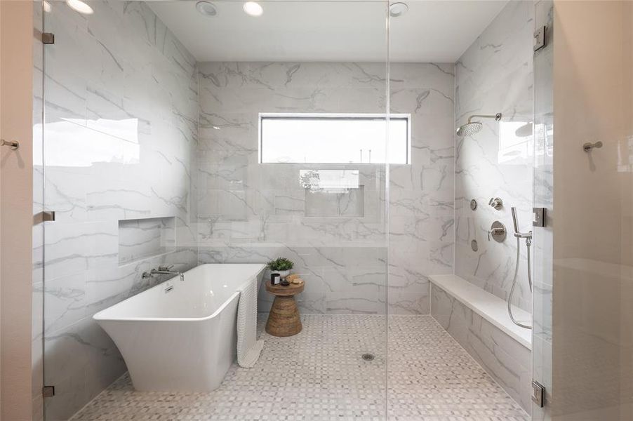 The windowed wet room soothes with a relaxing rainshower, bench and an oversized freestanding soaking tub.