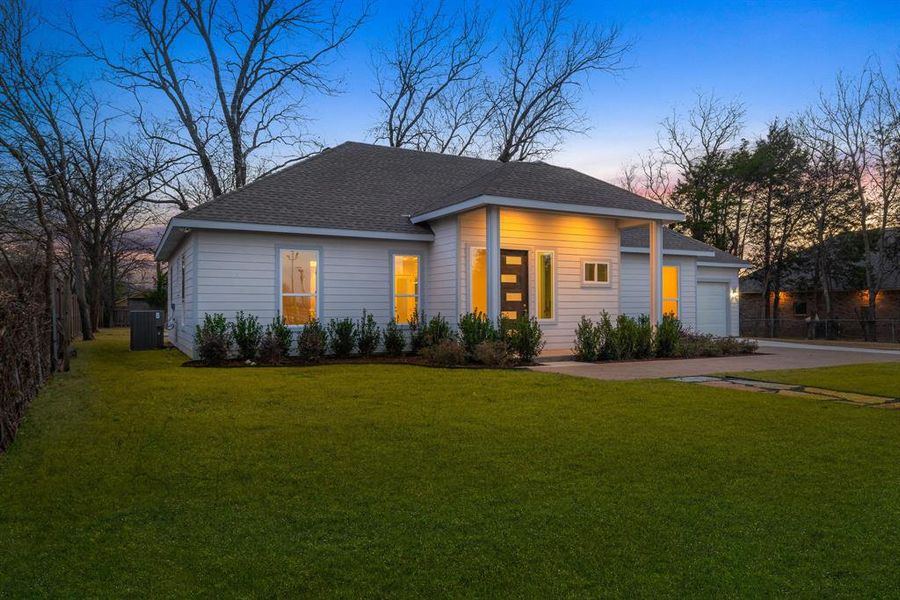 View of front of property featuring a garage and a lawn