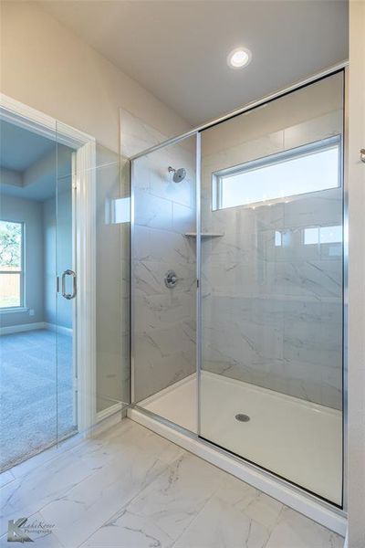 Bathroom with marble finish floors, a marble finish shower, and recessed lighting