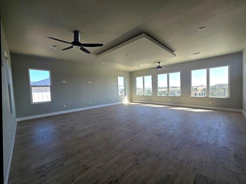 Unfurnished room featuring dark wood-type flooring and ceiling fan