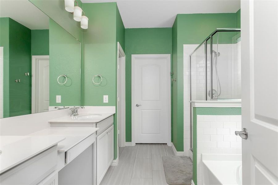 Full bath with vanity, a stall shower, and a garden tub