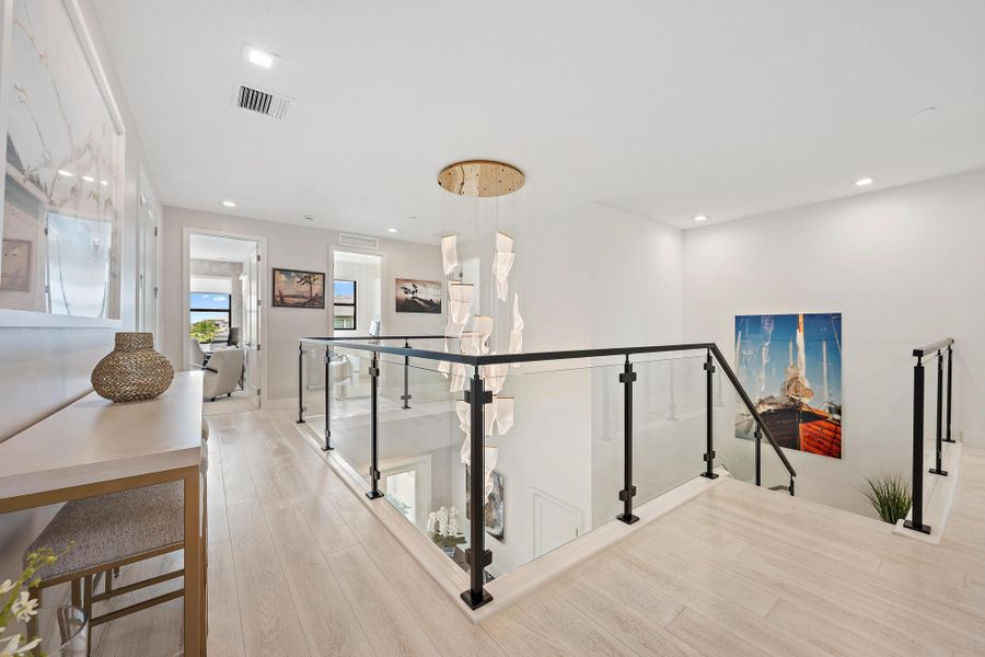 Custom lighting, high-end glass stair railing, and upgraded wood flooring.