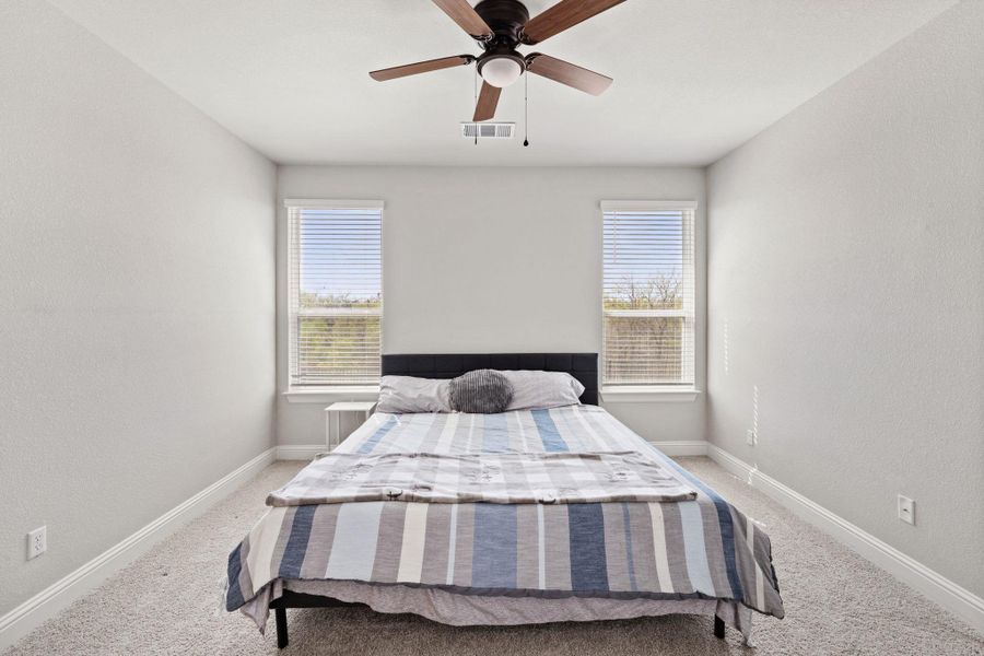 Bedroom featuring baseboards, multiple windows, and visible vents Bedroom featuring baseboards, multiple windows, and visible vents