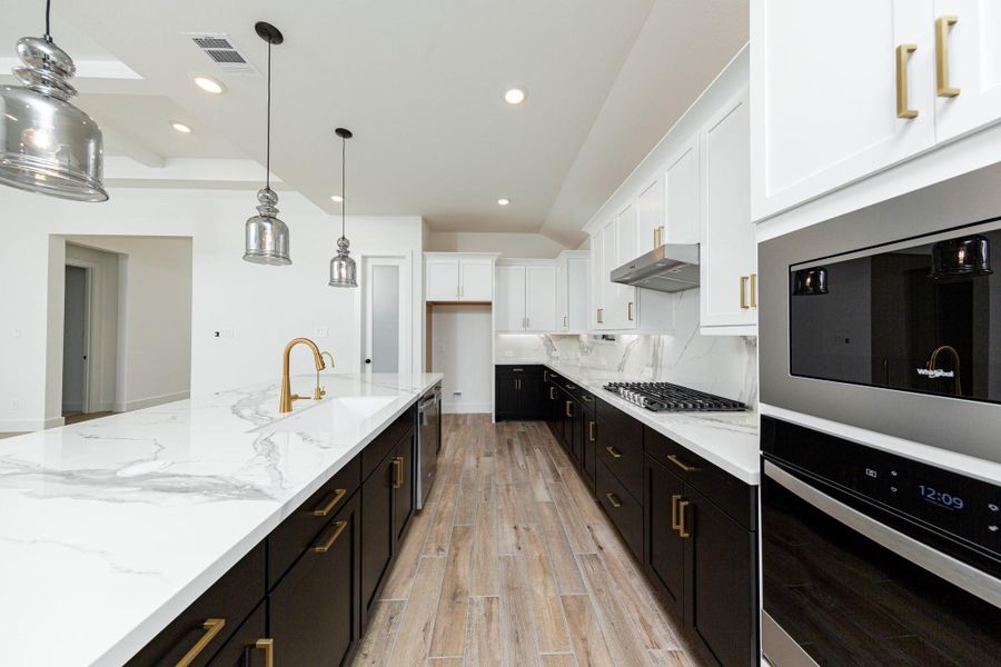 Discover the perfect blend of style and function in this modern kitchen, ready for your next culinary adventure. Equipped with high-end, stainless steel appliances, including a gas cooktop, built-in oven, and microwave.