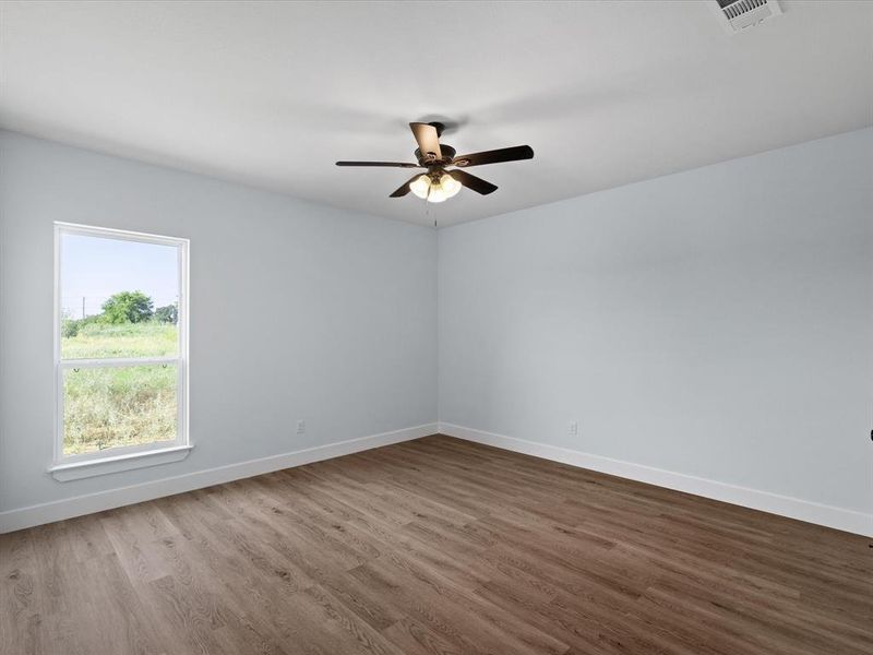 Empty room featuring a ceiling fan and wood finished floors
