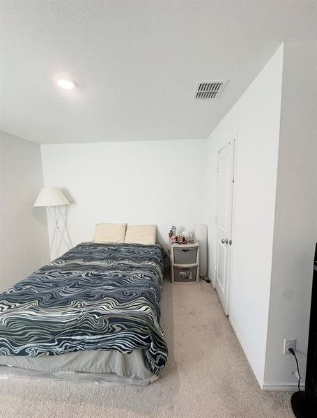 Bedroom featuring a textured ceiling and carpet