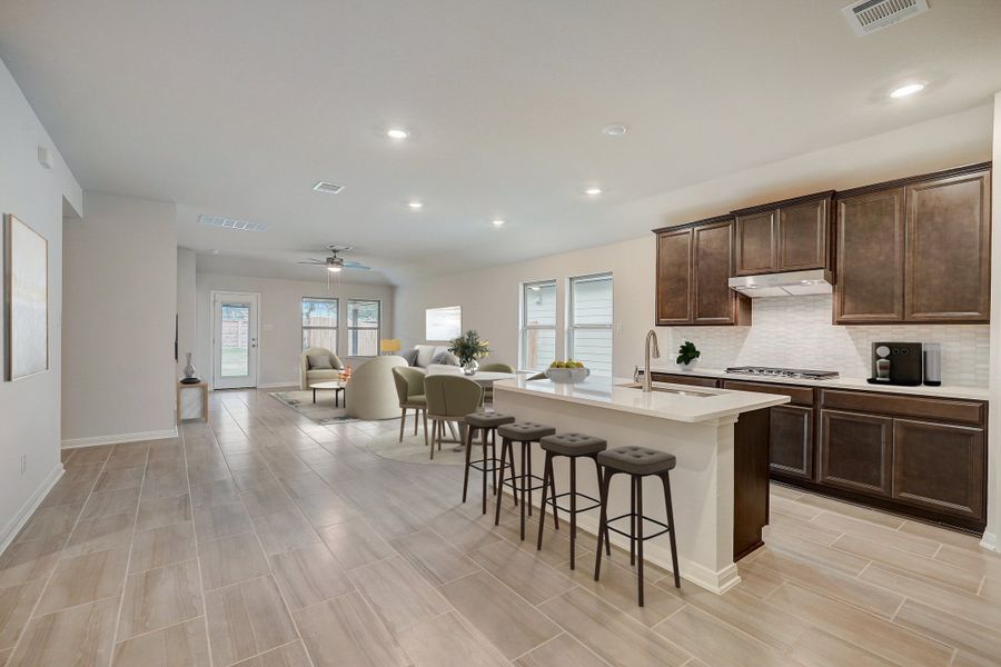 Virtually staged kitchen, dining room, and living room in the Oleander floorplan at a Meritage Homes community.