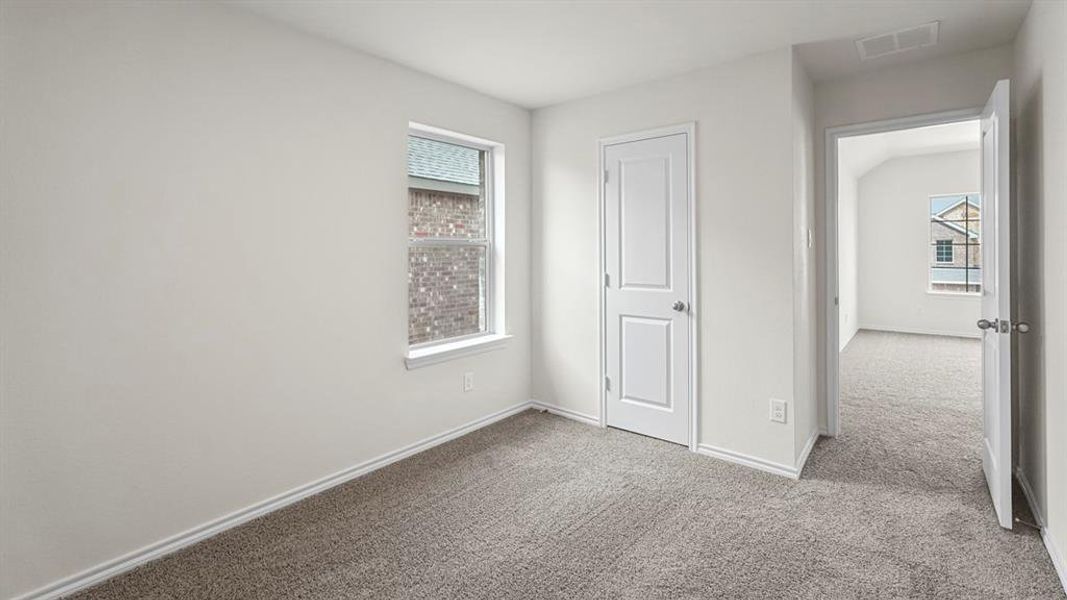 Carpeted interior room with white walls, white trim, a single window, and two paneled doors