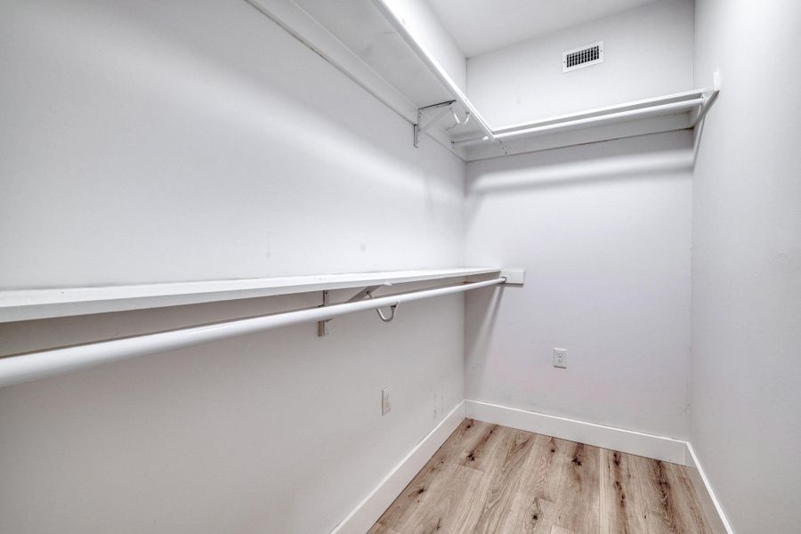 A well-organized walk-in closet offers ample storage space and durable flooring. A well-organized walk-in closet offers ample storage space and durable flooring.