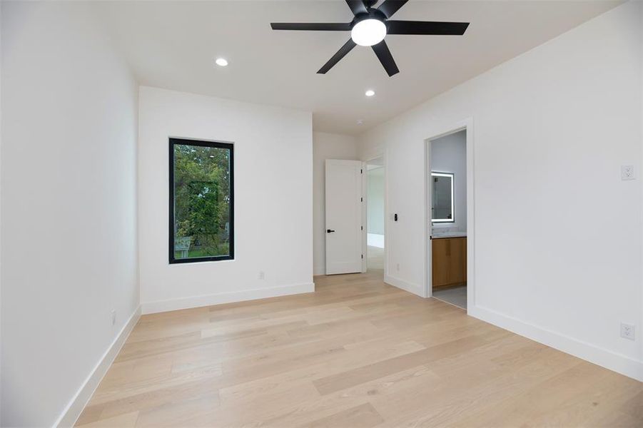 Unfurnished bedroom with light wood-type flooring, recessed lighting, ceiling fan, and ensuite bath Unfurnished bedroom with light wood-type flooring, recessed lighting, ceiling fan, and ensuite bath