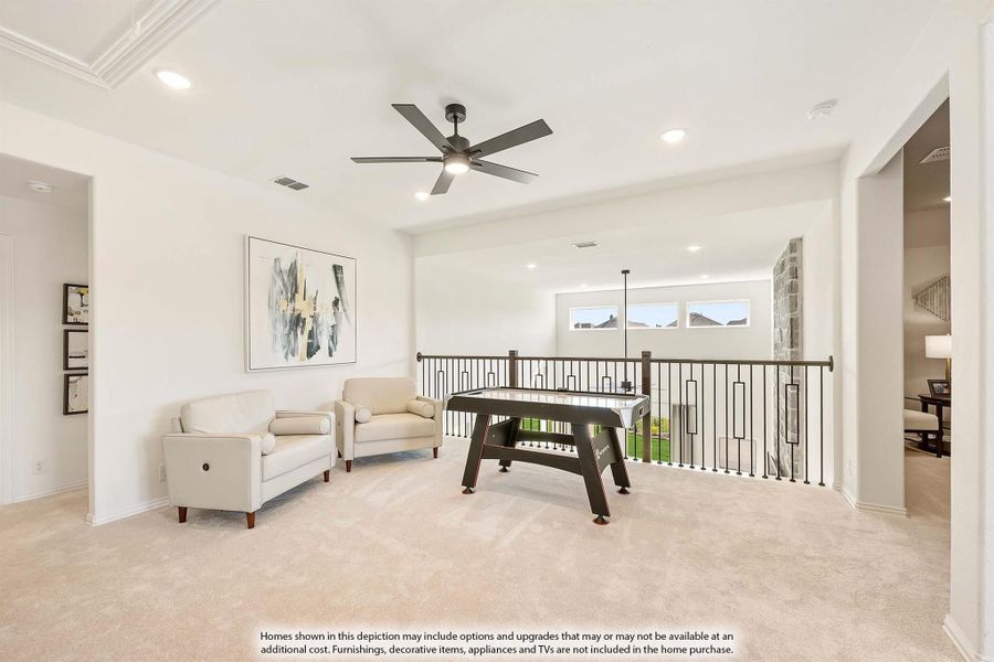 Upstairs game room with air hockey table, seating area, ceiling fan, and open railing overlooking lower level Upstairs game room with air hockey table, seating area, ceiling fan, and open railing overlooking lower level