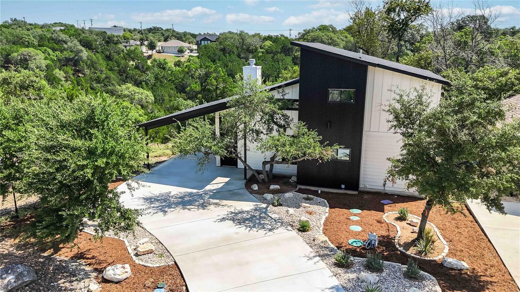 View of home's exterior with concrete curved driveway and an attached carport View of home's exterior with concrete curved driveway and an attached carport