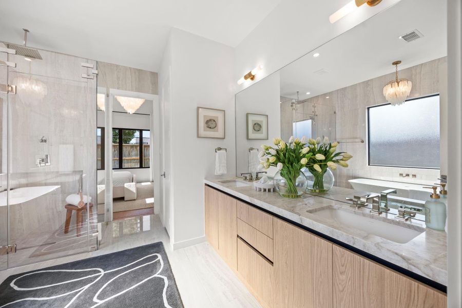 Quartz dual vanities w/ custom cabinetry & timeless light fixtures.