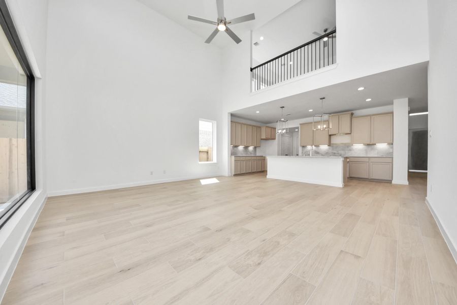 Gather the family and guests together in your lovely living room! Featuring soaring high ceilings, recessed lighting, ceiling fan, custom paint, gorgeous floors, and large windows that provide plenty of natural lighting throughout the day. Sample photo of completed home with similar floor plan. Actual colors and selections may vary.