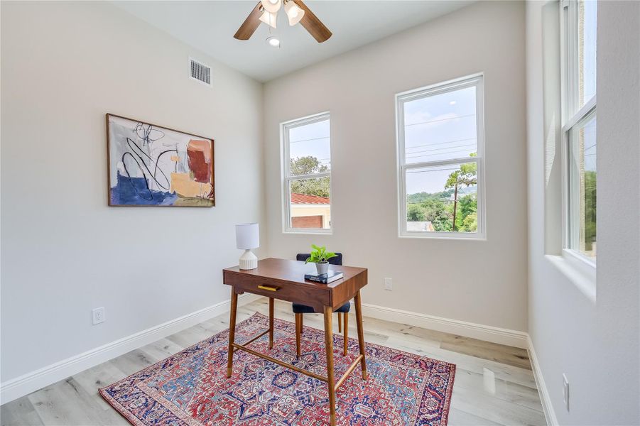 Office with ceiling fan, a wealth of natural light, and light hardwood / wood-style floors