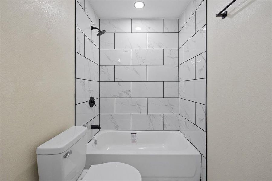 Bathroom featuring toilet and tiled shower / bath