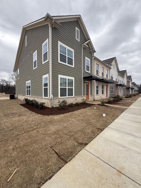 View of property exterior with a residential view and brick siding