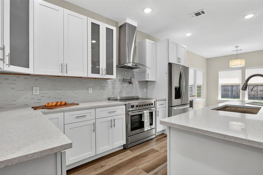 White shaker cabinets self closing with hardware, stainless steel seperate hood range above the stove from the microwave, Stainless steel fridge included with the sale of the home.
