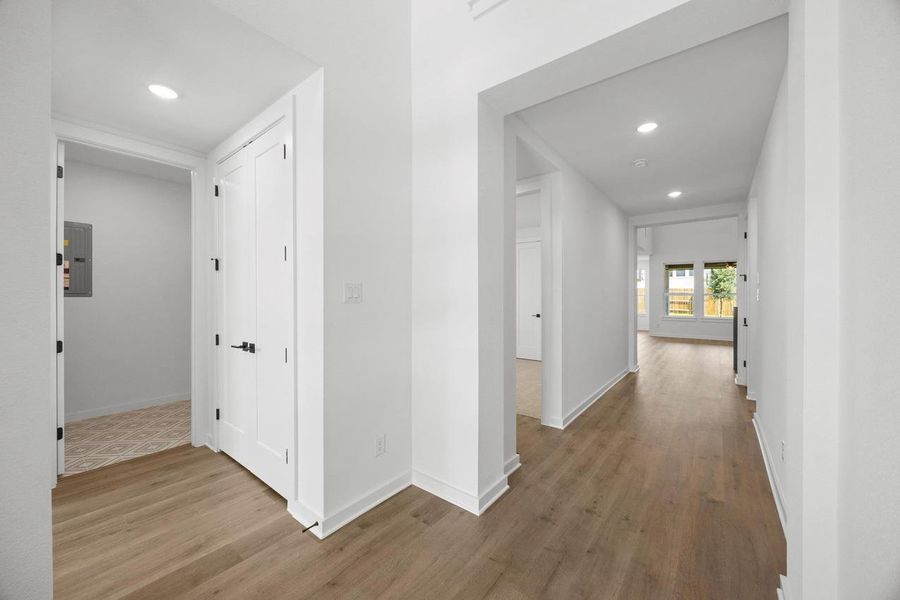 Hallway with recessed lighting, wood finished floors, and electric panel Hallway with recessed lighting, wood finished floors, and electric panel