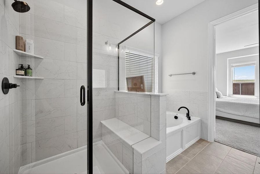 Modern bathroom featuring a glass-enclosed shower with black fixtures and a built-in bench