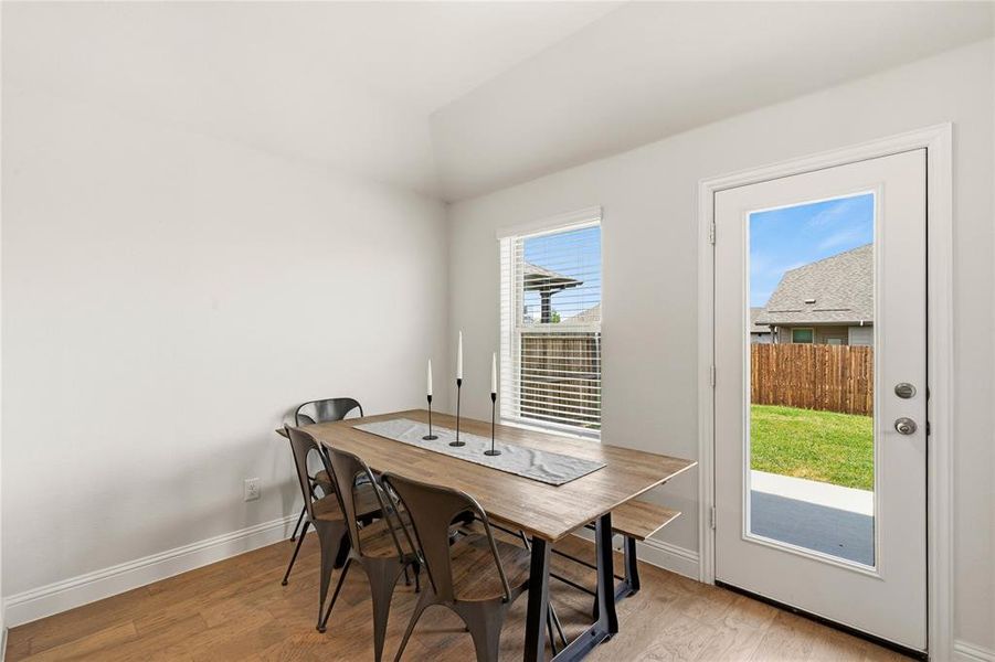 Dining area featuring wood-finish flooring, white baseboards, and a glass-paneled exterior door