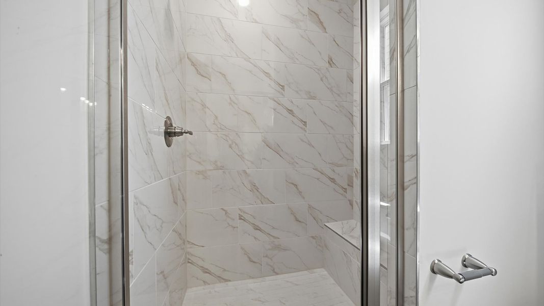 Spacious and modern primary bathroom with tiled walk-in shower and first-class double vanity setup Spacious and modern primary bathroom with tiled walk-in shower and first-class double vanity setup