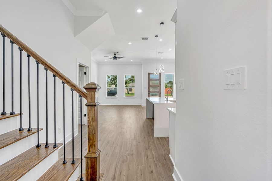Staircase located toward the back of the home featuring black metal balusters that continue the modern design elements seen throughout the home.