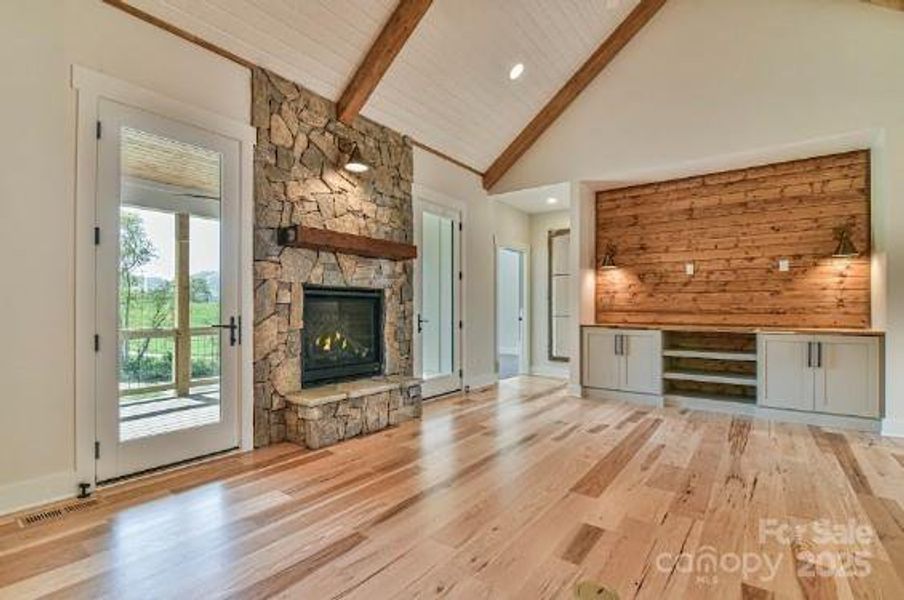 Great Room with a stone fireplace and patio doors flanking either side. Similar photo.