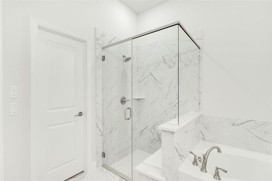 Bathroom with glass-enclosed shower and soaking tub, both featuring white marble tile walls and chrome fixtures Bathroom with glass-enclosed shower and soaking tub, both featuring white marble tile walls and chrome fixtures