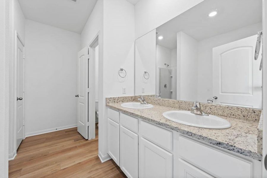 The primary bathroom includes granite countertops, double vanities, soaking tub, walk-in shower and enclosed water closet.