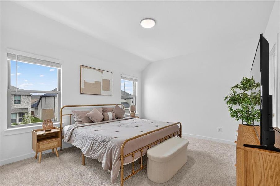 Carpeted bedroom featuring two large windows, a flat ceiling, and a flush-mount overhead light fixture