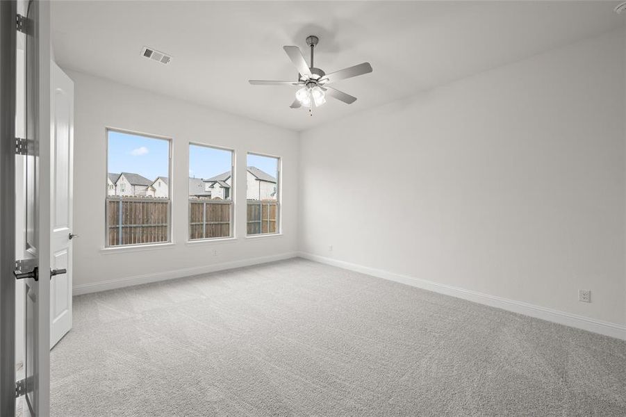 Empty room with light carpet, ceiling fan, and baseboards Empty room with light carpet, ceiling fan, and baseboards