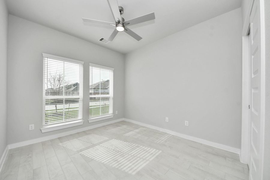 Inviting guest suite. The room features elegant 5-panel doors with sleek, contemporary hardware. Sink your feet into the plush, fluffy carpet that invites comfort and warmth. Large windows flood the space with an abundance of natural light, framed by privacy blinds that offer the perfect balance between openness and seclusion.
