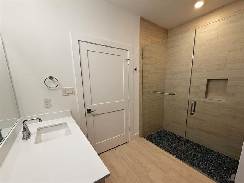 Bathroom with vanity, a stall shower, light wood-style floors, and recessed lighting