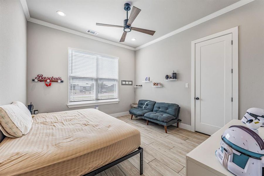 Bedroom featuring light wood-style flooring, ornamental molding, a ceiling fan, and recessed lighting