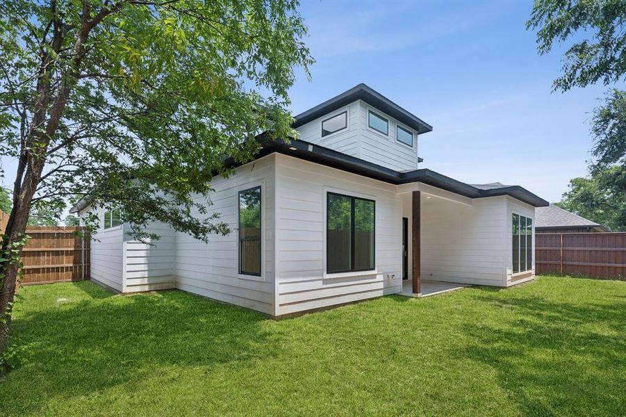 Rear view of property with a lawn