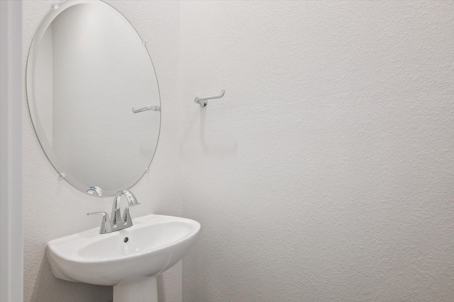 A bathroom with a round mirror. A bathroom with a round mirror.