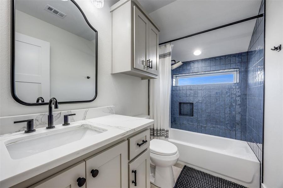 Upstairs bathroom with tile shower / bathtub combination and quartz vanity.