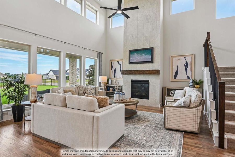 Open living room with two-story ceiling, stone fireplace, hardwood floors, and large windows with backyard view. Open living room with two-story ceiling, stone fireplace, hardwood floors, and large windows with backyard view.