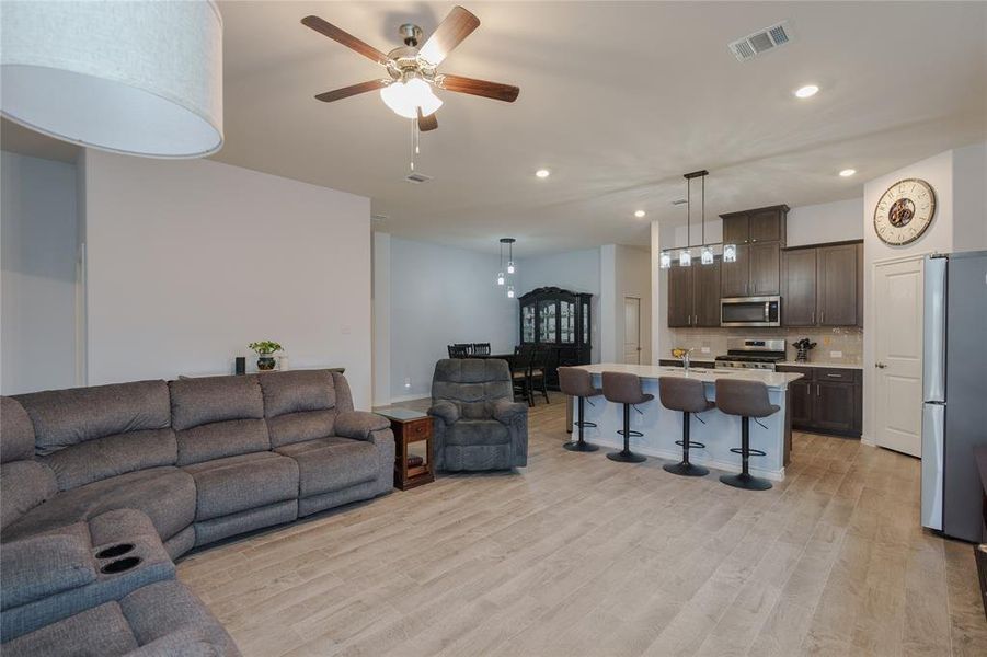 Living room with light hardwood / wood-style floors and ceiling fan