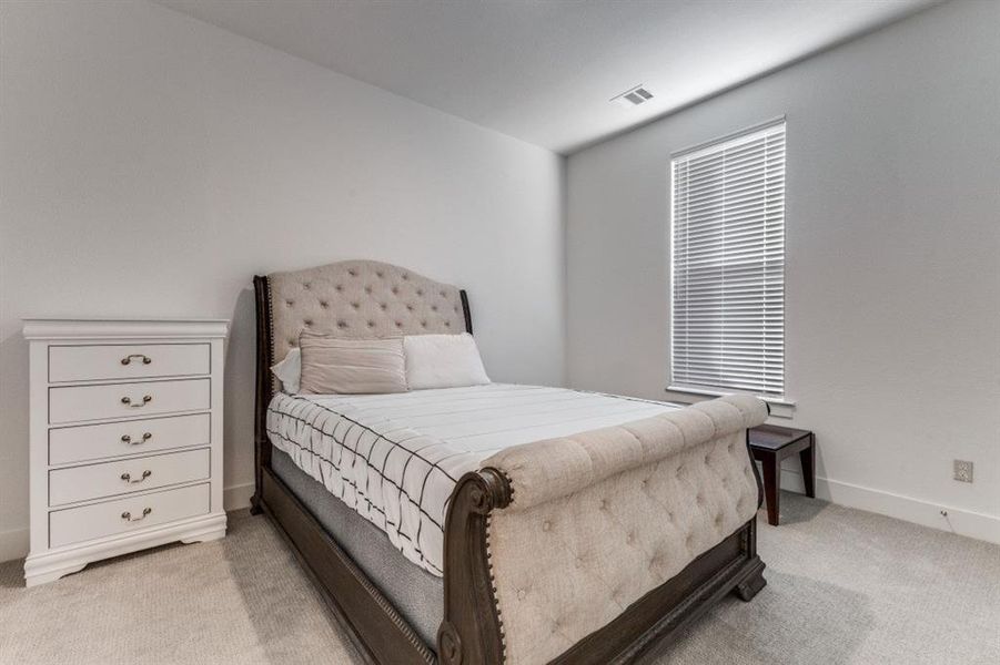 Bedroom featuring light carpet and baseboards