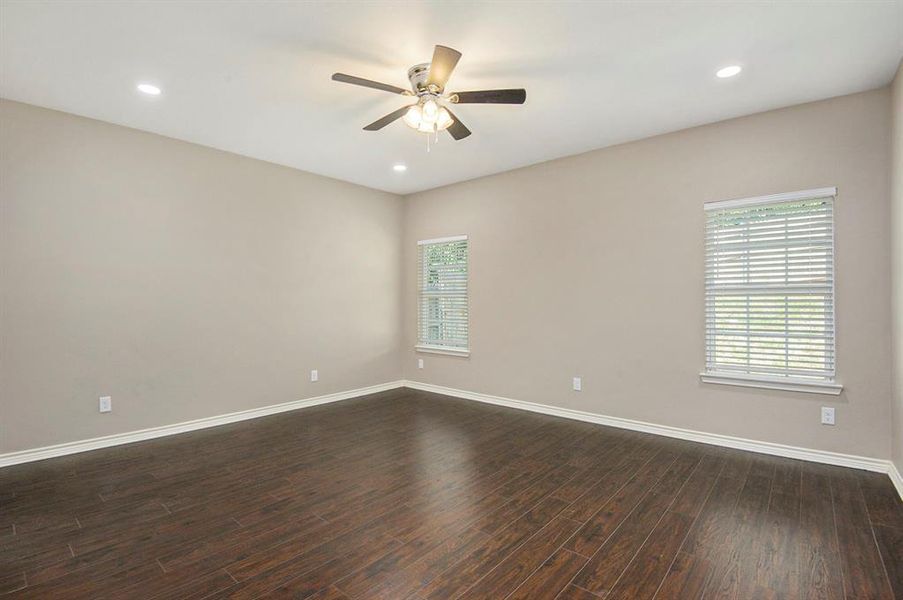 Spare room featuring dark wood-type flooring, a ceiling fan, and recessed lighting