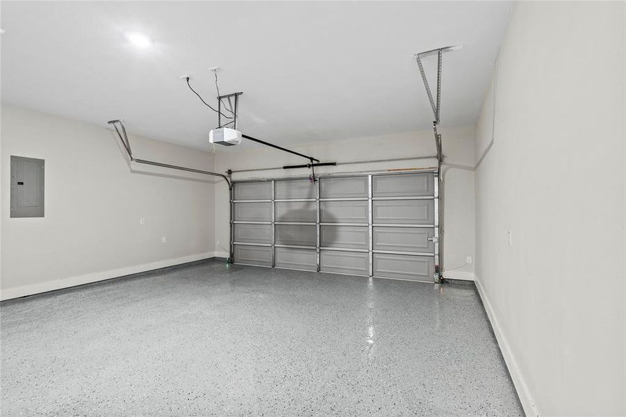 Garage featuring electric panel and a garage door opener