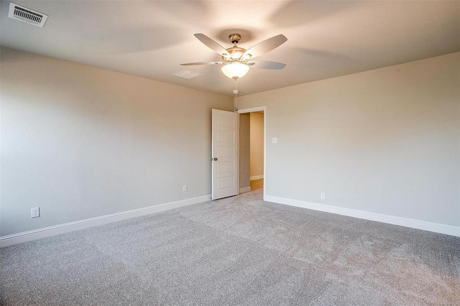 Carpeted spare room featuring ceiling fan